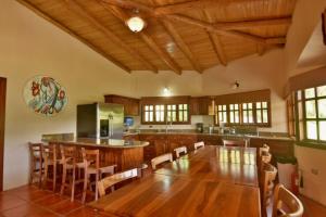a large kitchen with a wooden table and chairs at Pie in the Sky 3 Amazing Luxury Home with Lake and Volcano view in El Fosforo