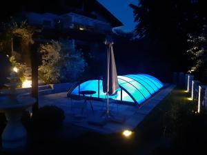 a swimming pool at night with an umbrella and a table at Ferienwohnung Anna Zechner in Flattach
