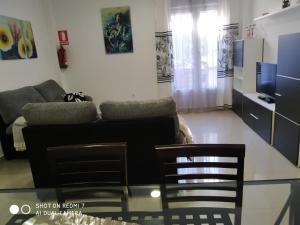 Apartamentos La Bodega في La Zarza: غرفة معيشة مع أريكة وبعض الكراسي