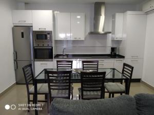 a kitchen with a glass table and chairs in it at Apartamentos La Bodega in La Zarza