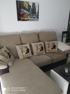 a brown couch with four pillows on it at Apartamentos La Bodega in La Zarza +24 photos