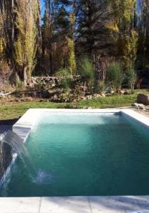 a swimming pool with a fountain in a yard at Cabañas Las Golondrinas in Potrerillos