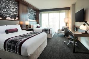 um quarto de hotel com duas camas e uma secretária em Texas A&M Hotel and Conference Center em College Station