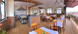 a restaurant with tables and chairs and a kitchen at Studio 69 Aparthotel in Iquitos
