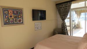 een slaapkamer met een bed en een televisie aan de muur bij Margate Beauty in Margate