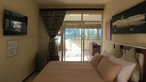 een slaapkamer met een bed en een glazen schuifdeur bij Margate Beauty in Margate