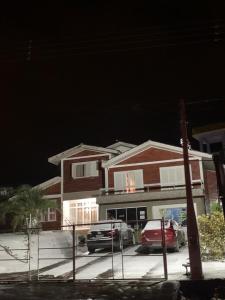 Pousada Recanto Aparados da Serra في كامبارا: سيارة حمراء متوقفة أمام منزل