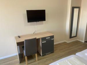 einen Schreibtisch mit einem TV darüber in einem Zimmer in der Unterkunft Danubiana Apartments 7-8 in Kladovo