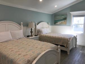 a bedroom with two beds and a window at Falmouth Heights Motor Lodge in Falmouth