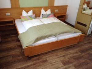 Cama grande en habitación con suelo de madera en Hotel Erika, en Arzl im Pitztal