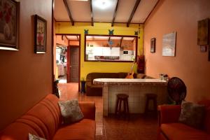 a living room with a couch and a kitchen at Casa Quepos in Quepos