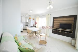 sala de estar con sofá, TV y mesa en 1006 - Apartamento com vista para o mar, en Bombinhas