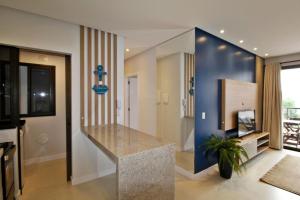 ein Wohnzimmer mit einer Theke und einer blauen Wand in der Unterkunft 1088 - Apartamento novo Praia de Bombinhas in Bombinhas