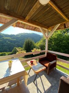 eine Terrasse mit einem Tisch und einer Bank und Aussicht in der Unterkunft Turizam Raković in Ivanjica