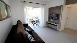 sala de estar con sofá y TV en 1070 - Praia de Bombinhas locação de temporada., en Bombinhas
