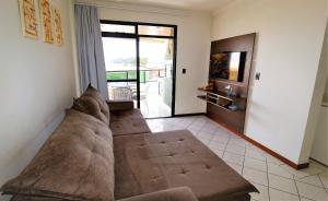 sala de estar con sofá y TV en 1038 - Apartamento com vista para o mar na Avenida De Bombinhas, en Bombinhas