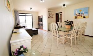 cocina y sala de estar con mesa y sillas en 1038 - Apartamento com vista para o mar na Avenida De Bombinhas, en Bombinhas
