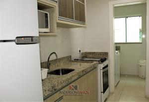een keuken met een wastafel en een fornuis bij 1040 - Apartamento para locação em Bombinhas - Residencial Egídio Pinheiro Apto 206 A in Bombinhas