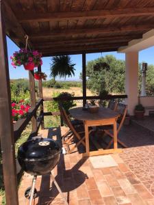een patio met een grill en een tafel en stoelen bij Casa Vittoria in Palau +22 foto's