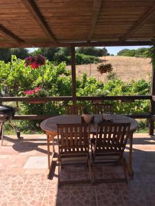 een houten tafel en stoelen op een terras bij Casa Vittoria in Palau