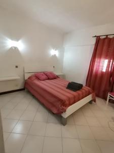 um quarto com uma cama com lençóis vermelhos e uma cortina vermelha em Dunfermline Apartment em Albufeira