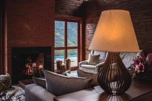 a living room with a lamp and a fireplace at Valle Ristretto in Gramado