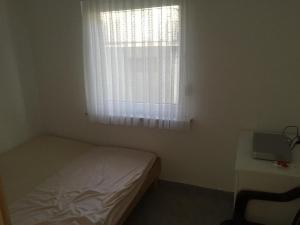 een kleine slaapkamer met een bed en een raam bij Tomo Apartment in Starigrad-Paklenica