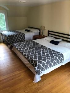 two beds sitting in a room with wooden floors at Town Plot Waterbury in Waterbury