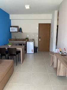 a kitchen and dining room with a table and chairs at Ondas Praia Resort Apartamento in Porto Seguro