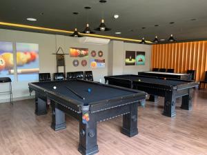 two ping pong tables in a room with billards at Ondas Praia Resort Apartamento in Porto Seguro