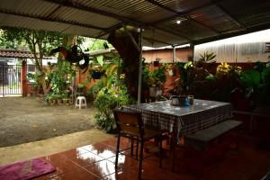 un patio con una mesa y un montón de plantas en Casa Quepos, en Quepos