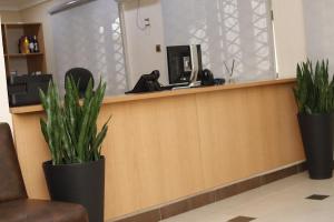 a reception counter with two potted plants on it at AYAAKAJE GUEST HOUSE in Ibadan