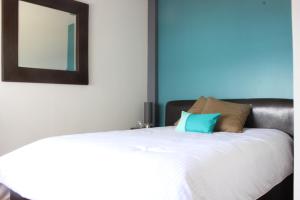 um quarto com uma cama branca e um espelho em Downtown Mexico City, full apartment em Cidade do México