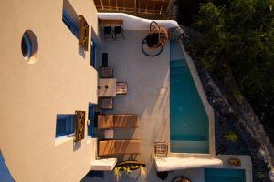 an overhead view of a swimming pool next to a building at Pink Freud Villas Santorini in Oia