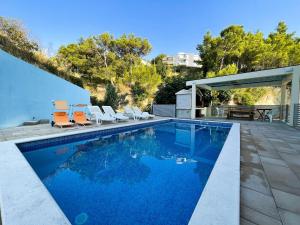 a swimming pool with some chairs and a table at Vacation Rentals Croatia in Split
