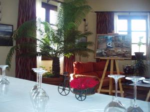 einen Tisch mit Weingläsern und eine Pflanze im Wohnzimmer in der Unterkunft Apartamentos Rurales La Muralla II in Cañete