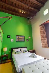 a bedroom with a green wall and a bed at Hotel La Palma Centro Histórico in Santa Marta