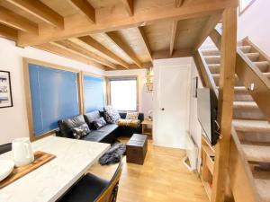 a living room with a couch and a staircase at High Bernation Haus in Dinner Plain
