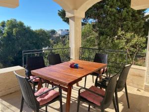 Une table et des chaises en bois sont disponibles sur la terrasse. dans l'établissement Villa Tibet, à Yalıkavak