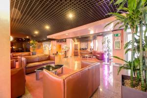 a lobby with couches and a table and chairs at Hotel Galileo in Milan