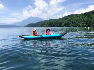 a man and a woman in a kayak on a lake at Petit Hotel Kazekozou in Shinano