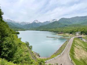 a view of a lake with mountains in the background at Petit Hotel Kazekozou in Shinano