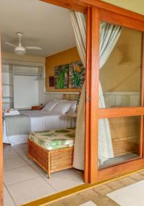 a bedroom with a bed and a glass door at Pousada Ponta de Areia in Prado +58 photos