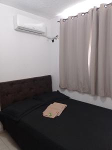 カンポス・ドス・ゴイタカゼスにあるLua E Agua Xのベッドルーム1室(ベッド1台、黒毛布、窓付)