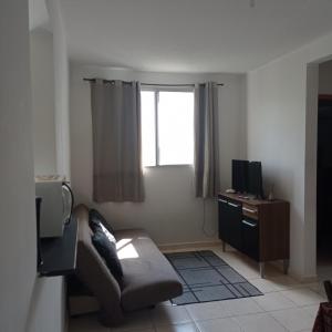 カンポス・ドス・ゴイタカゼスにあるLua E Agua Xのソファとテレビのあるリビングルーム