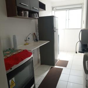 カンポス・ドス・ゴイタカゼスにあるLua E Agua Xのキッチン(テレビ、シンク、冷蔵庫付)