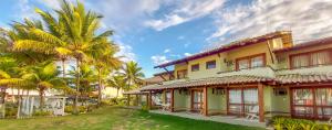 a building with palm trees in front of it at Pousada Ponta de Areia in Prado