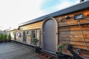 a wooden house with a door on a deck at HouseBoat next to AMSTEL in Amsterdam