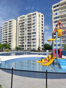 a pool with a slide in front of some buildings at INCREIBLE APARTAMENTO Puerto Azul Club House RICAURTE in Ricaurte