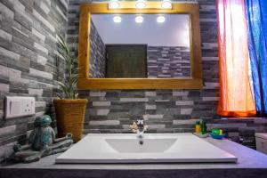 un bagno con lavandino e specchio di Forcus Cabanas ad Arugam